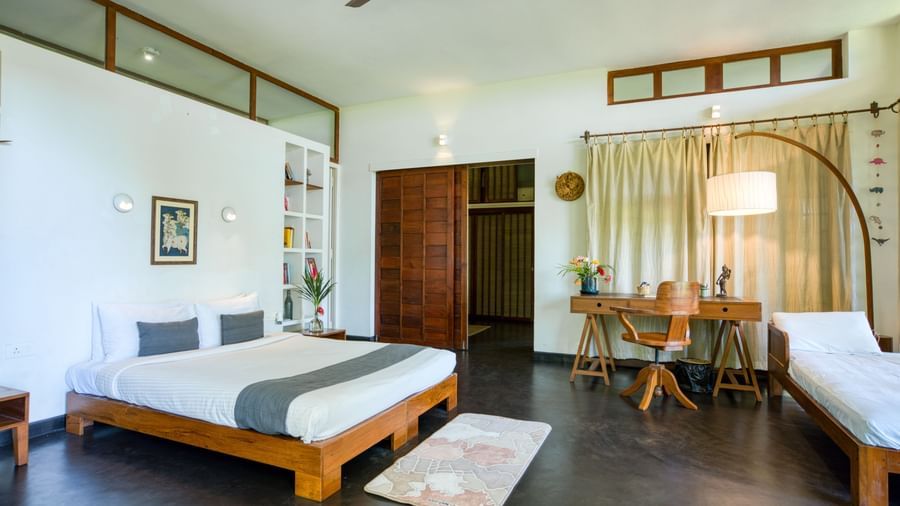Elegant bedroom with a king-size bed, a study table and chair, complete with elegant lights accentuating  the contemporary vibe of the room.