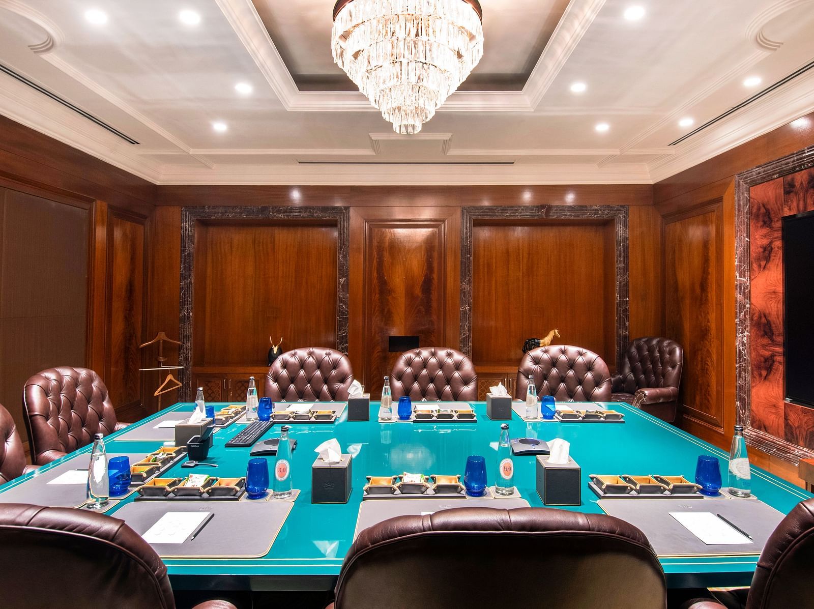 Full view of the Senate Boardroom at The Claridges New Delhi, featuring a wall-mounted TV screen at the far end