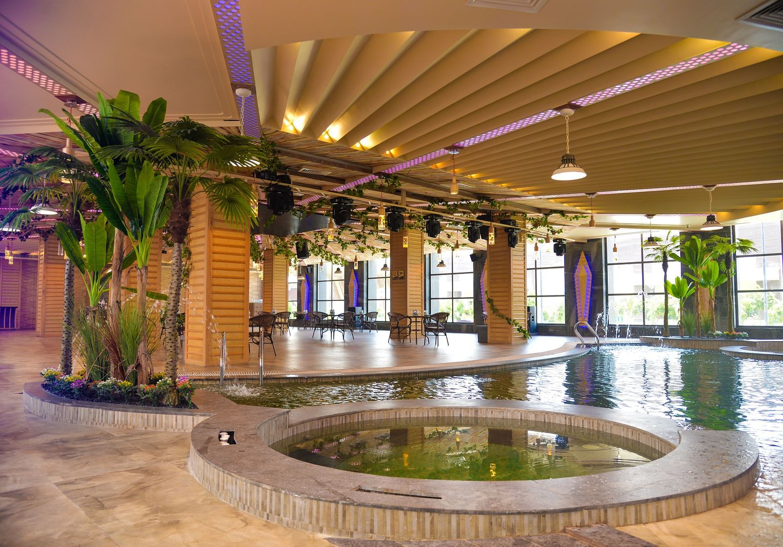 An indoor swimming pool right next to a dining area - Golden Blossom Imperial Resorts