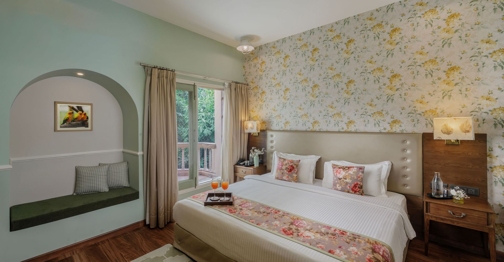 Elegant guest room with a double bed, modern furnishings, and floral wallpaper at Karma Chalets.