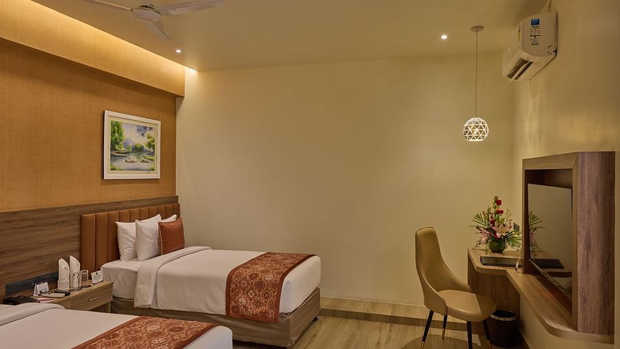 An image of our Family Room with a queen size bed and an extra bed placed in front of a wall-mounted television