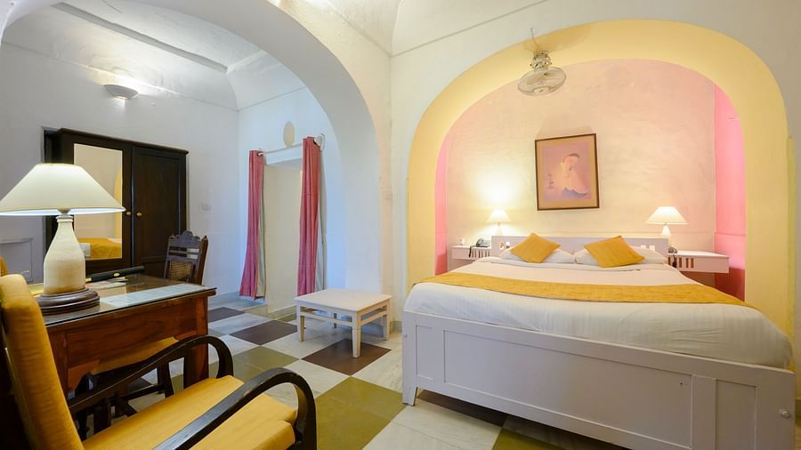 Hill Fort Kesroli 14th Century Alwar - interior view of the Raunak Mahal - Village View room with a queen size bed, a chair and a lamp