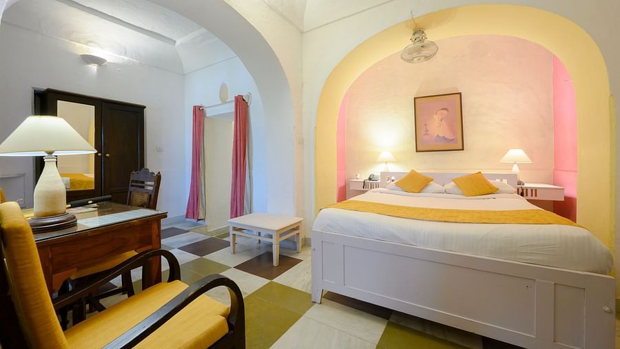 Hill Fort Kesroli 14th Century Alwar - interior view of the Raunak Mahal - Village View room with a queen size bed, a chair and a lamp