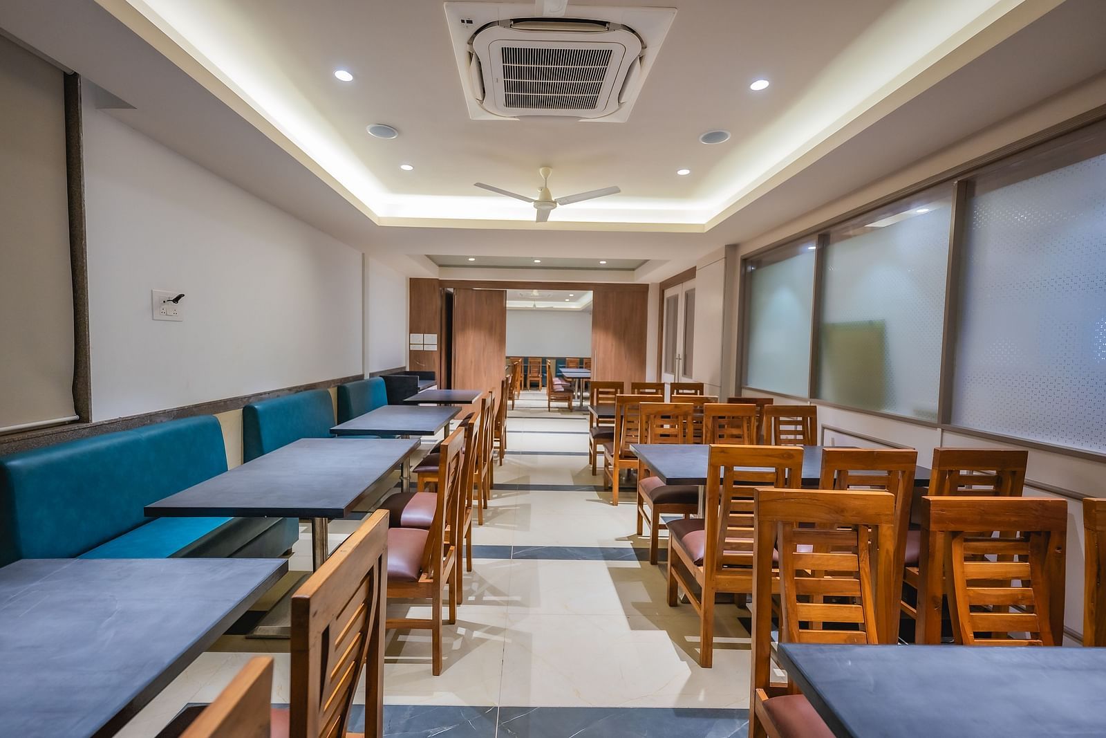 A dining room with empty wooden tables and chairs along the wall | Lotus Leaf Boutique Hotel