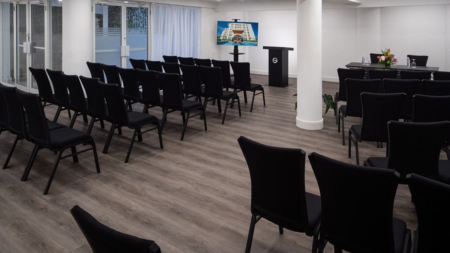 A conference room in Montego Bay with black chairs placed in a theatre style setting - S Hotel Montego Bay, Jamaica