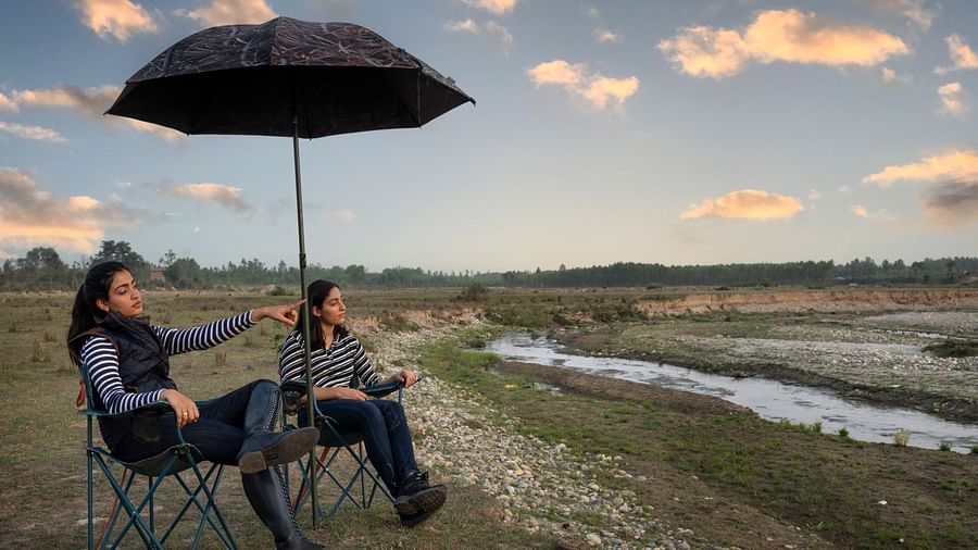 A couple of friends enjoying a picnic under an umbrella - Aalia Jungle Resort & Spa