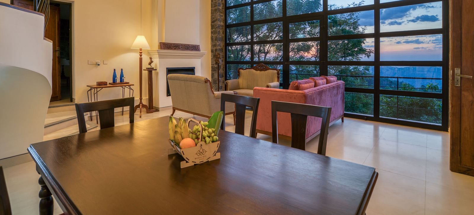 An image of a dining area with a window that gives a view of the outside world | Mango Hill, Yercaud