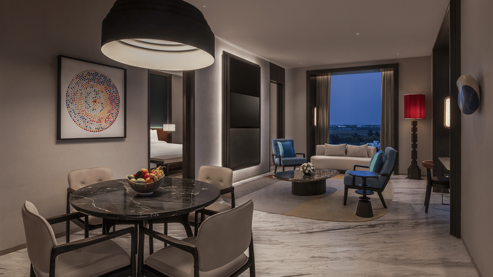 Premium Suite interior at The Residency Signature Madurai showing a dining table with chairs and a separate living area with a sofa in the back.