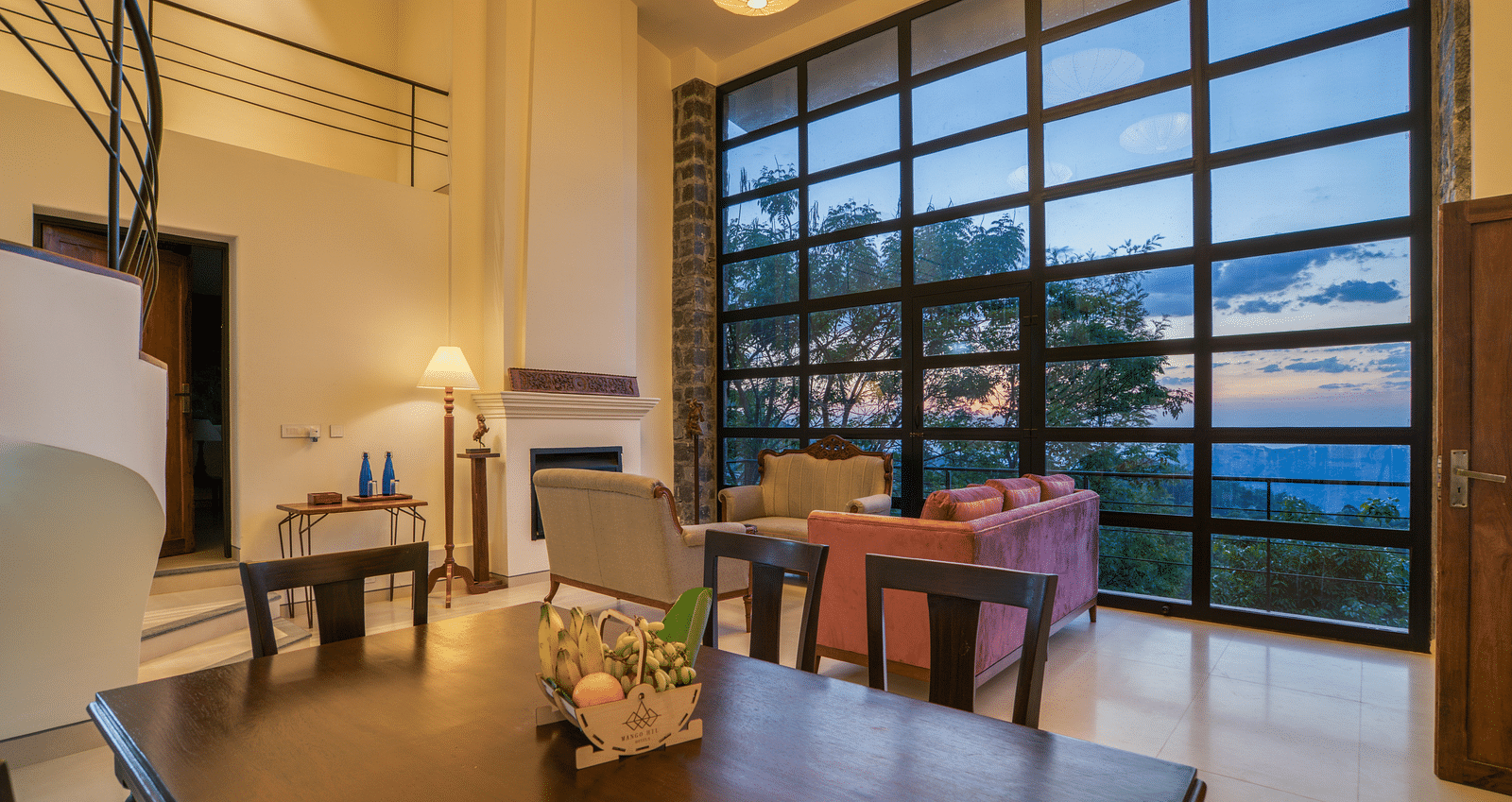An image of a dining area with a window that gives a view of the outside world | Mango Hill, Yercaud