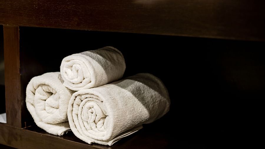 a close up shot of towels kept in the wardrobe - Wedlock Greens Hotel Resorts Dhanbad