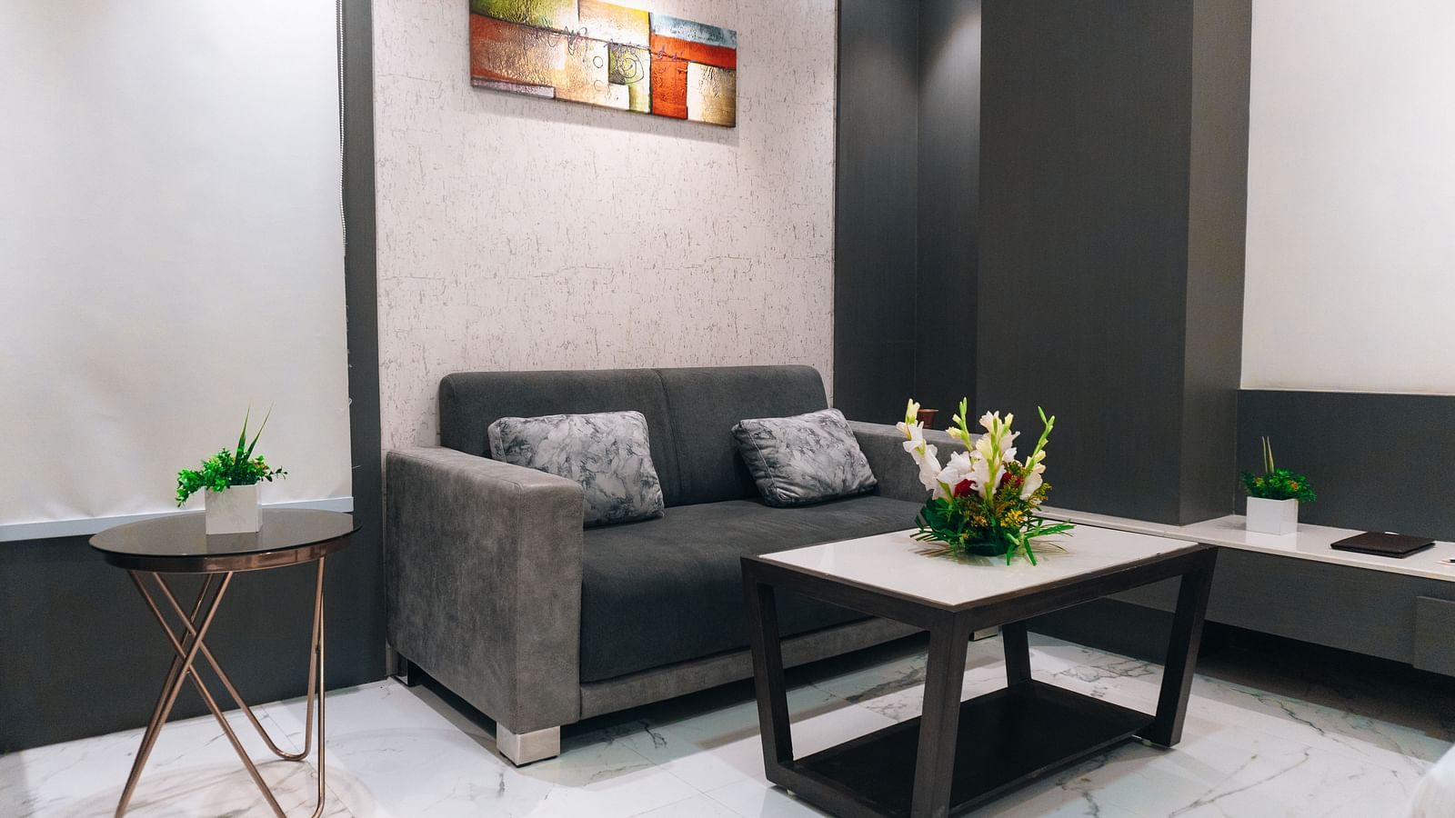 a living area with a sofa and a table - Jardin Hotels