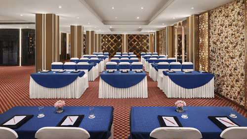 A banquet hall in New Delhi with ambient lighting and comfortable seating - Deventure Sarovar Portico, Patel Nagar
