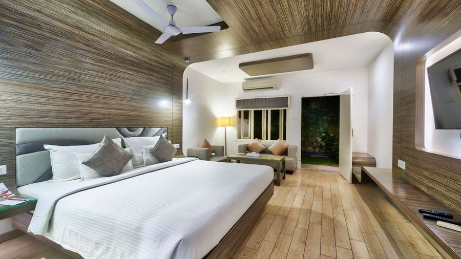 A spacious room with a king size bed, wooden flooring, seating area and ceiling fan at Grande Bay Resort & Spa.