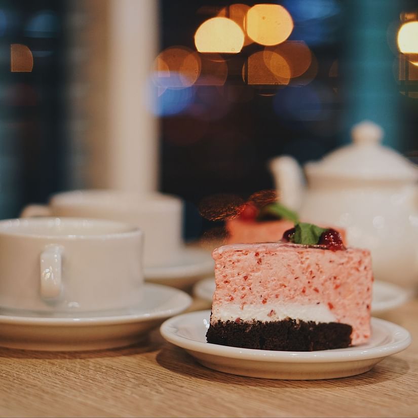 Delecious cake kept on table with tea kettle