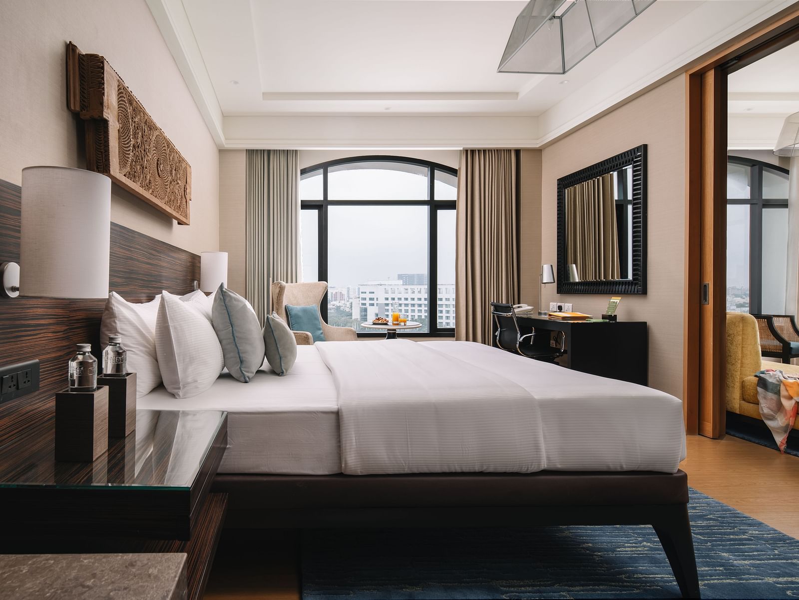 A comfortable suite with a spacious layout and modern furniture and a large window with the view of the city, perfect for a relaxing stay at The Raintree, St. Mary's Road.