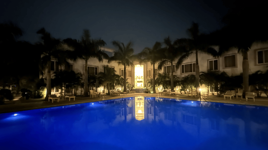 A glowing blue swimming pool lit up after sunset at AS Hotels, Khajuraho.