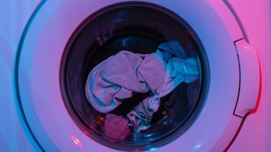 Front-loading washing machine with clothes inside, captured through the transparent circular door.