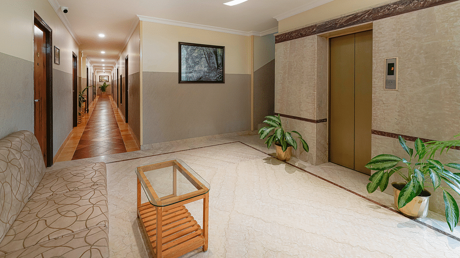 An area near the lift with cosy seating arrangement and modern lighting - Cross Roads Inn, Bengaluru