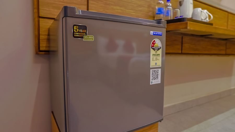  Compact fridge placed in wooden cabinet at Max Hotel Prayagraj.