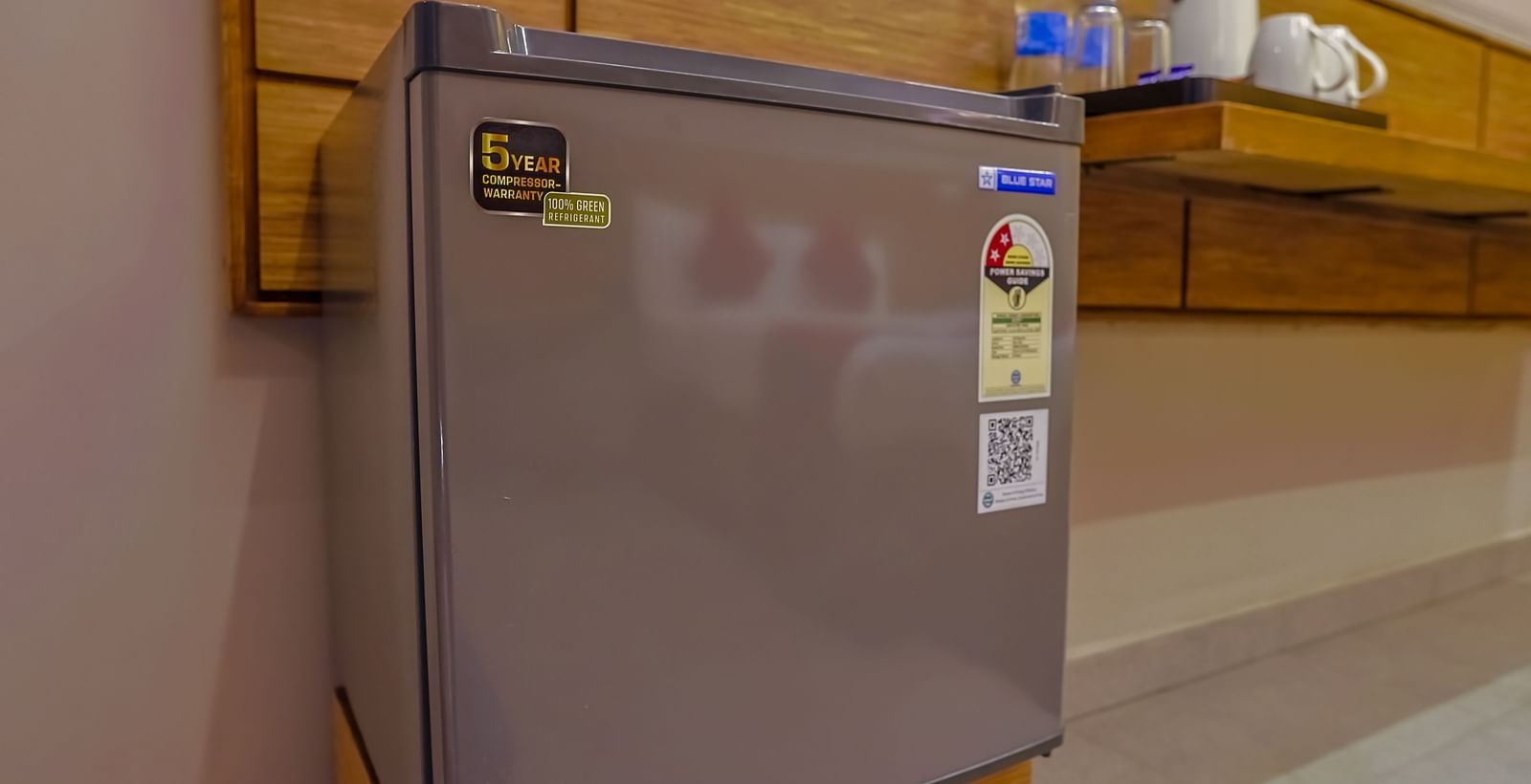  Compact fridge placed in wooden cabinet at Max Hotel Prayagraj.
