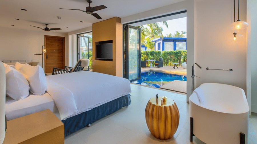 Pool Deluxe Villa at Azaya Beach Resort featuring a plush bed next to a bathtub facing the TV mounted on the wall next to which the door opens to a private pool