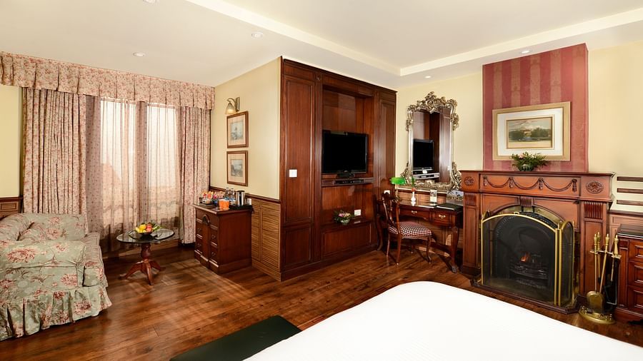 a king size bed facing the window and a fireplace positioned to the right side of the bed - Mayfair Hill Resort, Darjeeling 