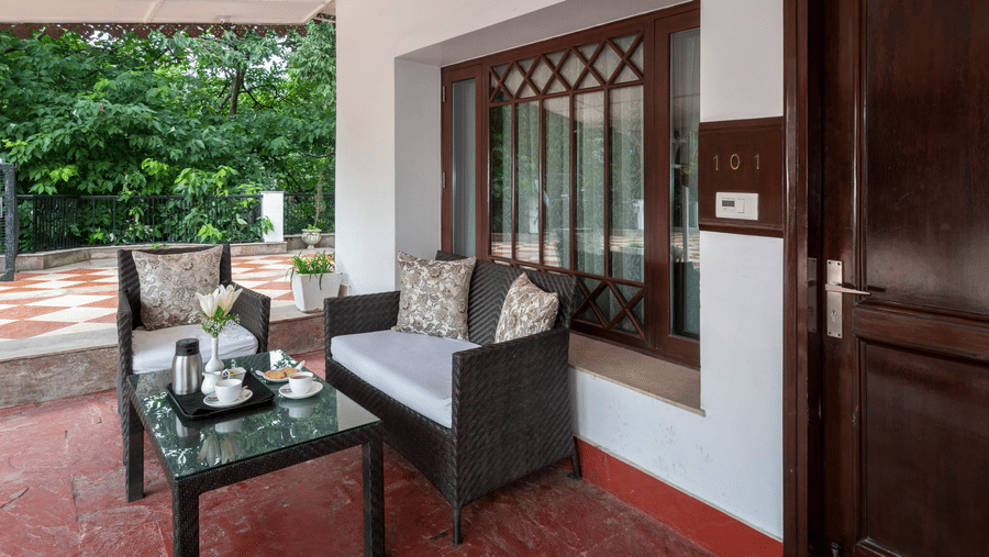 outside seating area with a tree seater couch outside the Club Rooms at The Claridges Nabha Residence