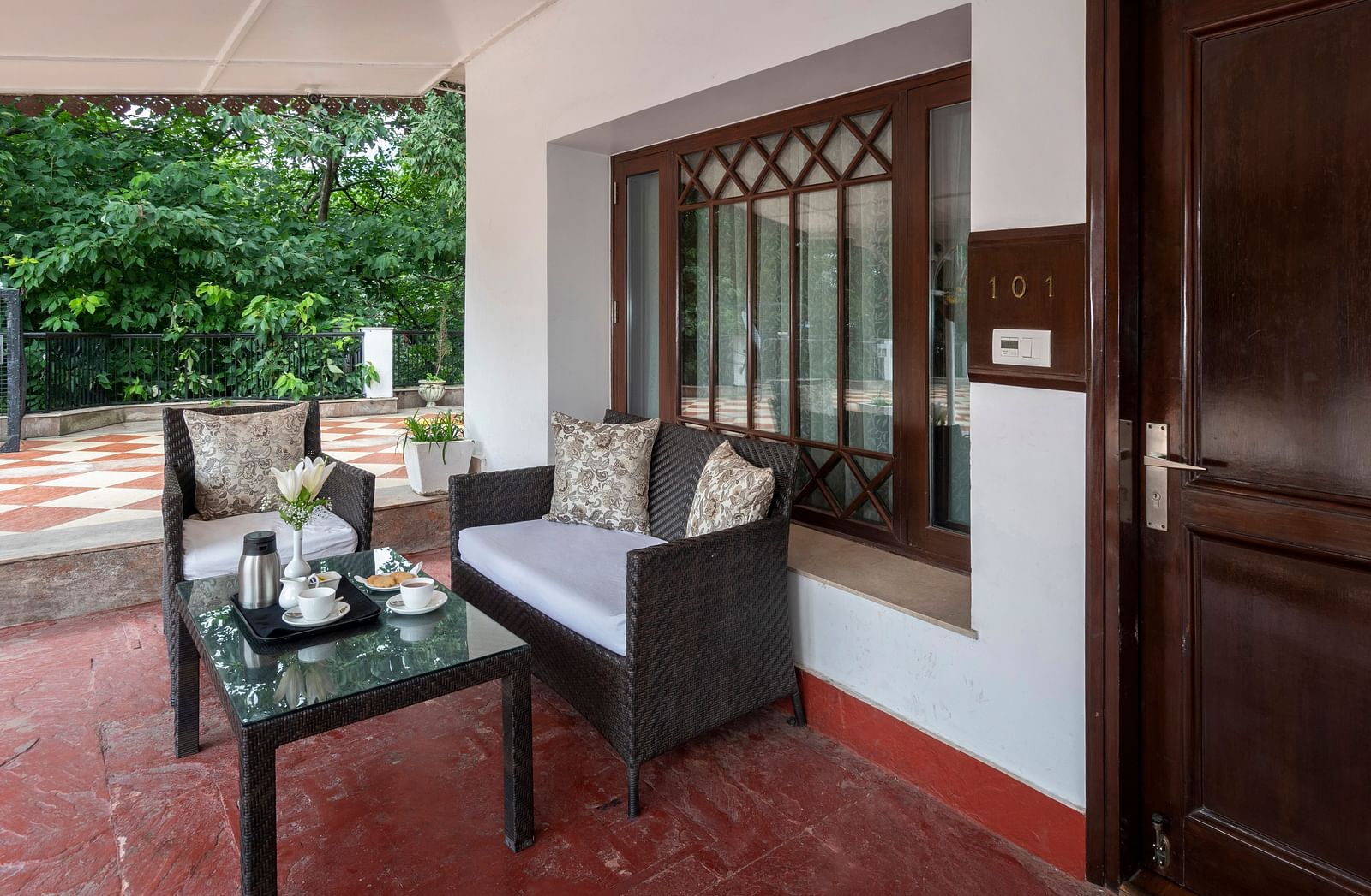 outside seating area with a tree seater couch outside the Club Rooms at The Claridges Nabha Residence