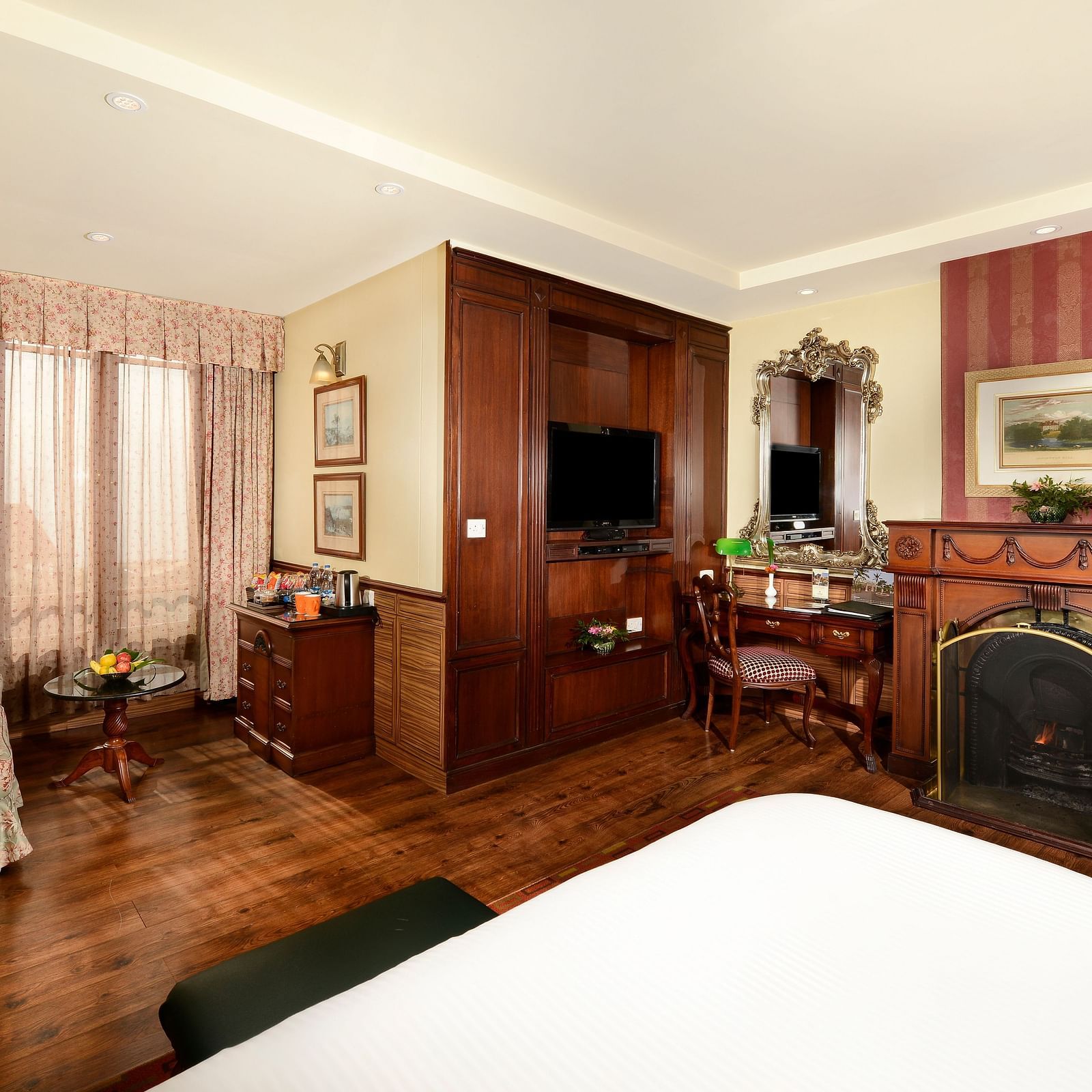 view from the bed overlooking the fireplace on the right and a seating space on the left - Mayfair Himalayan Spa Resort Kalimpong