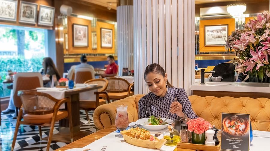 A woman enjoying delicious food in our Pickwick restaurant - Claridges Collection