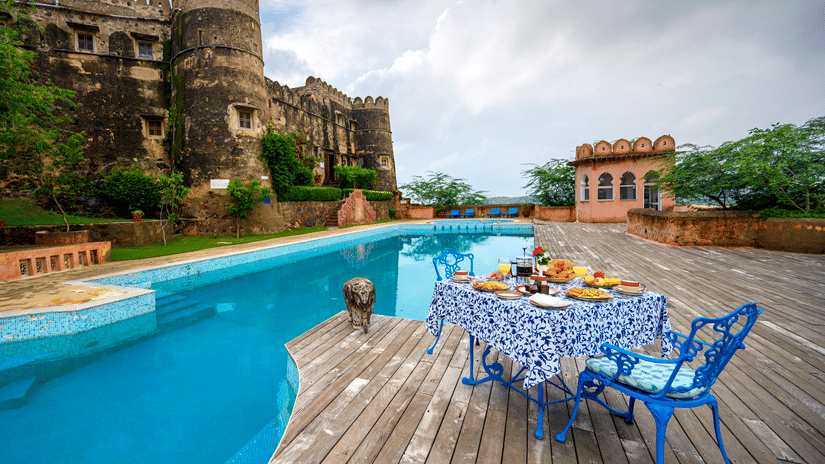 Hill Fort Kesroli 14th Century Alwar - image of a table and chair facing the property's swimming pool