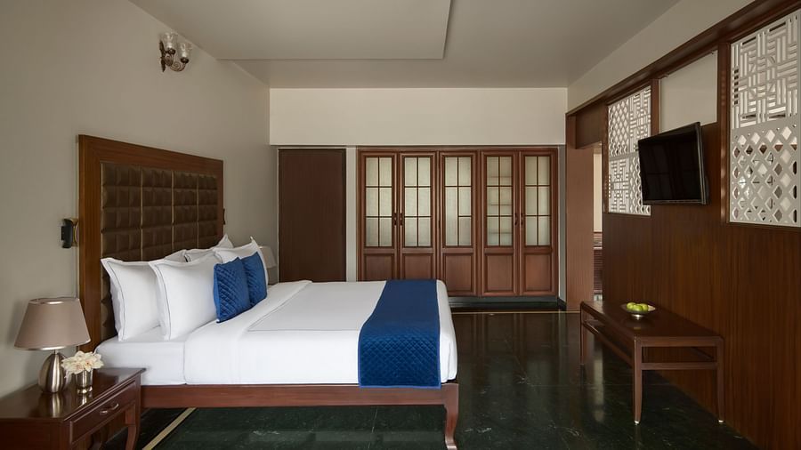 Signature Suite with a large bed, blue accents, a wall-mounted TV and a spacious, elegant design at DGV Resort by Treat, Silvassa.