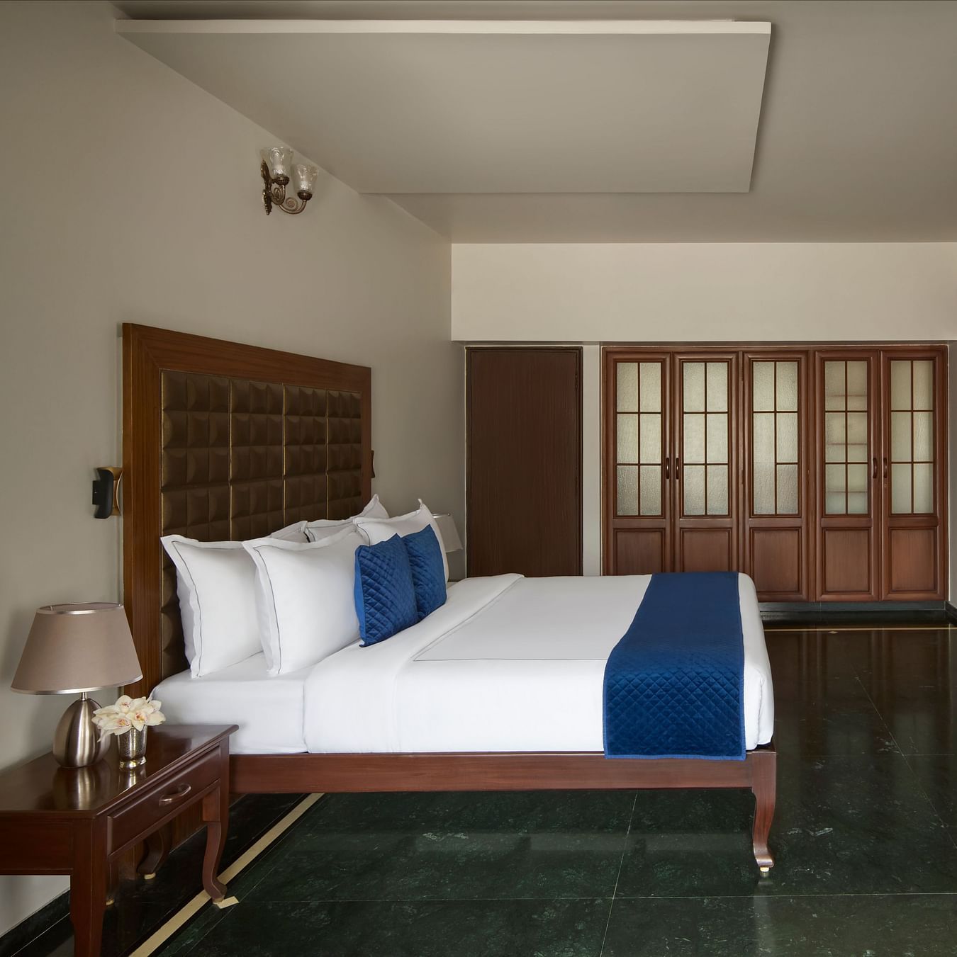 Signature Suite with a large bed, blue accents, a wall-mounted TV and a spacious, elegant design at DGV Resort by Treat, Silvassa.