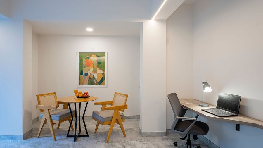 Corner workspace with table, lamp and desk setup at Nest by Rivido Apart Hotel, Bannerghatta Road