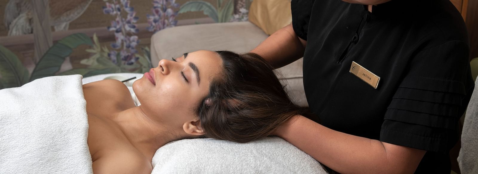 A woman recieving a head massage from a masseuse in Cinqtuair Spa - Claridges Collection