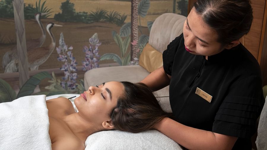 A woman recieving a head massage from a masseuse in Cinqtuair Spa - Claridges Collection