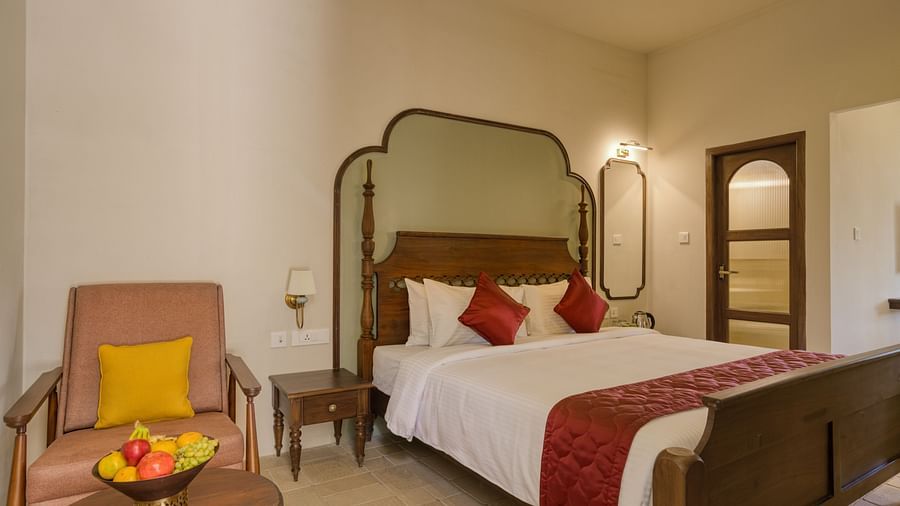 A double bed with a sofa next to it inside the studio | Mango Hill Shola Ooty