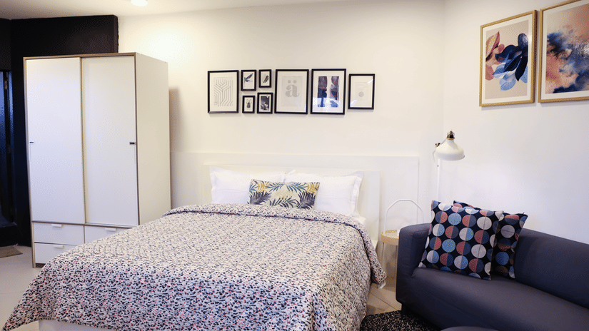 A well-furnished room with a bed, seating area, wardrobe, and modern lighting at Wabi - Sabi by Alamiko, Juhu.