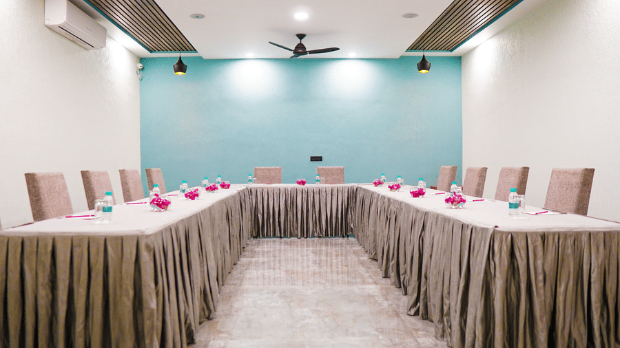  A conference room set up for a meeting with a long table covered in a tablecloth and chairs at The Golden Tusk, Jim Corbett