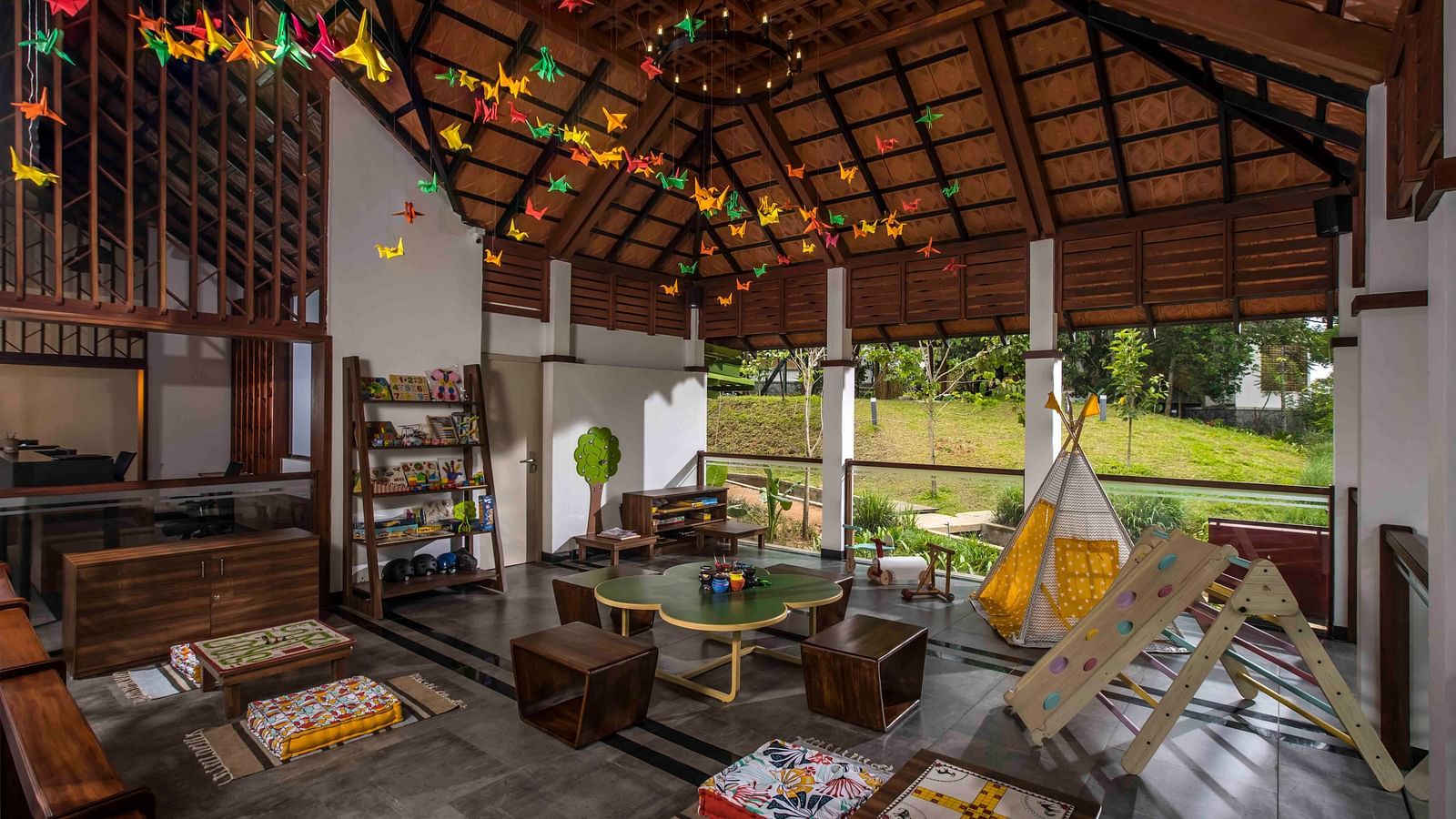 A shot of the kids play area featuring games and the area is decorated with colourful light. Great Trails Wayanad by  GRT hotels.