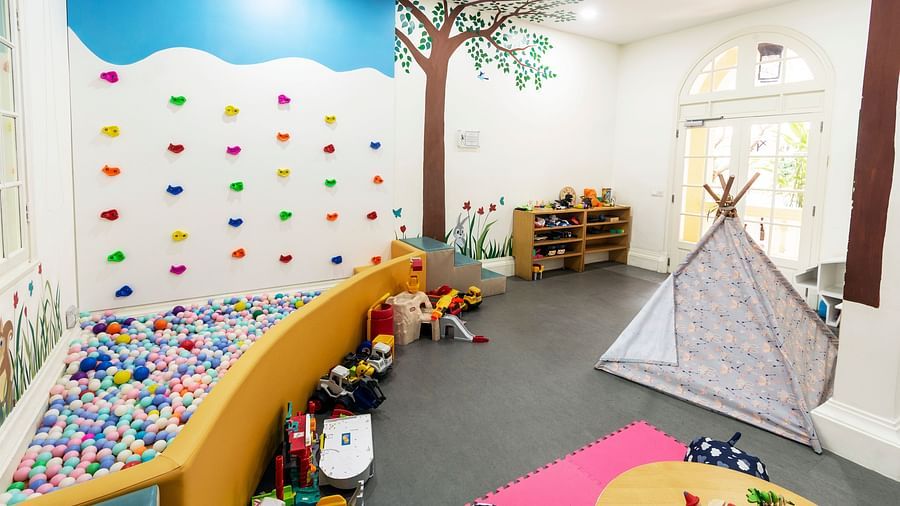 A colourful and playful children's playroom with a tree mural and various toys | Central Mansions, Phnom Penh