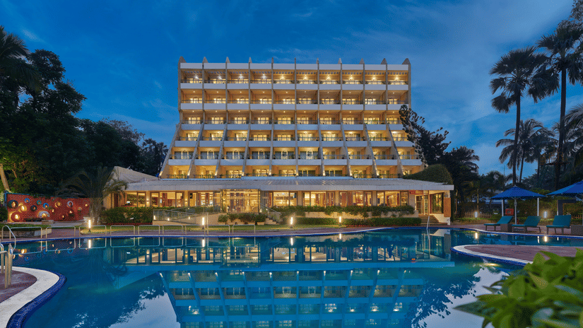 An overview of The Resort, Mumbai (Resort for Wedding Near Mumbai), during twilight showcasing the hotel facade and pool.