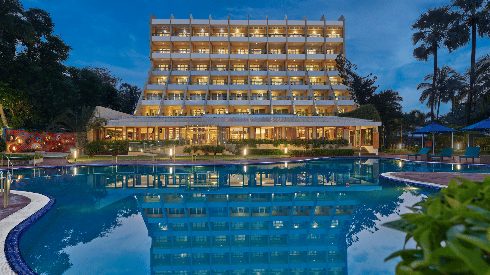 An overview of The Resort, Mumbai (Resort for Wedding Near Mumbai), during twilight showcasing the hotel facade and pool.