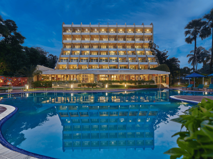 An overview of The Resort, Mumbai (Resort for Wedding Near Mumbai), during twilight showcasing the hotel facade and pool.