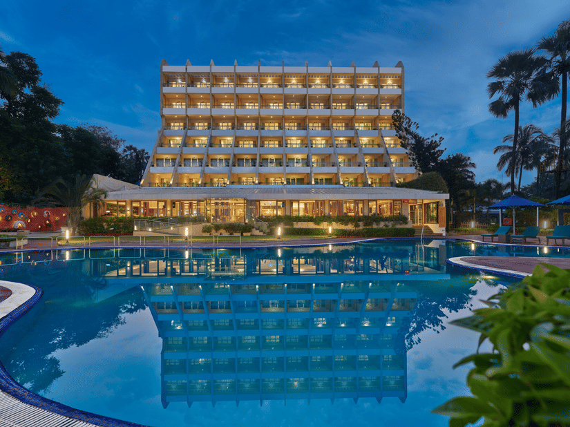 An overview of The Resort, Mumbai (Resort for Wedding Near Mumbai), during twilight showcasing the hotel facade and pool.