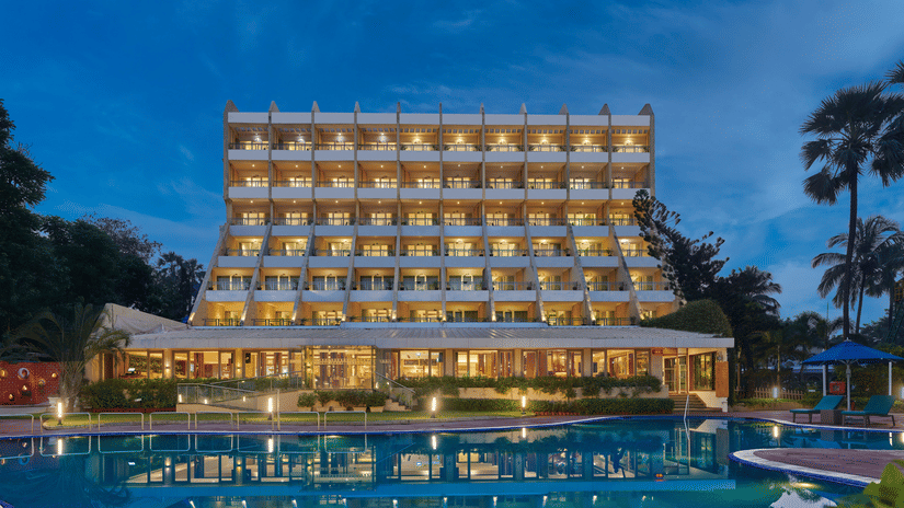 An overview of The Resort, Mumbai, a resort for wedding near Mumbai, during twilight showcasing the hotel facade and pool.