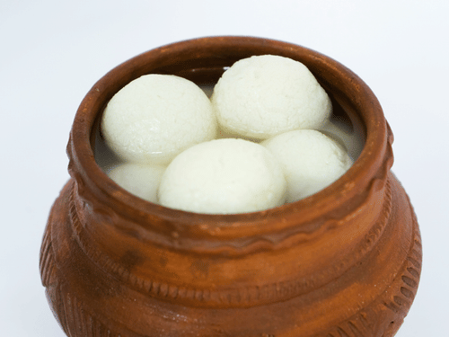 A clay pot filled with cottage cheese balls called rosogulla, dipped in sugar syrup.
