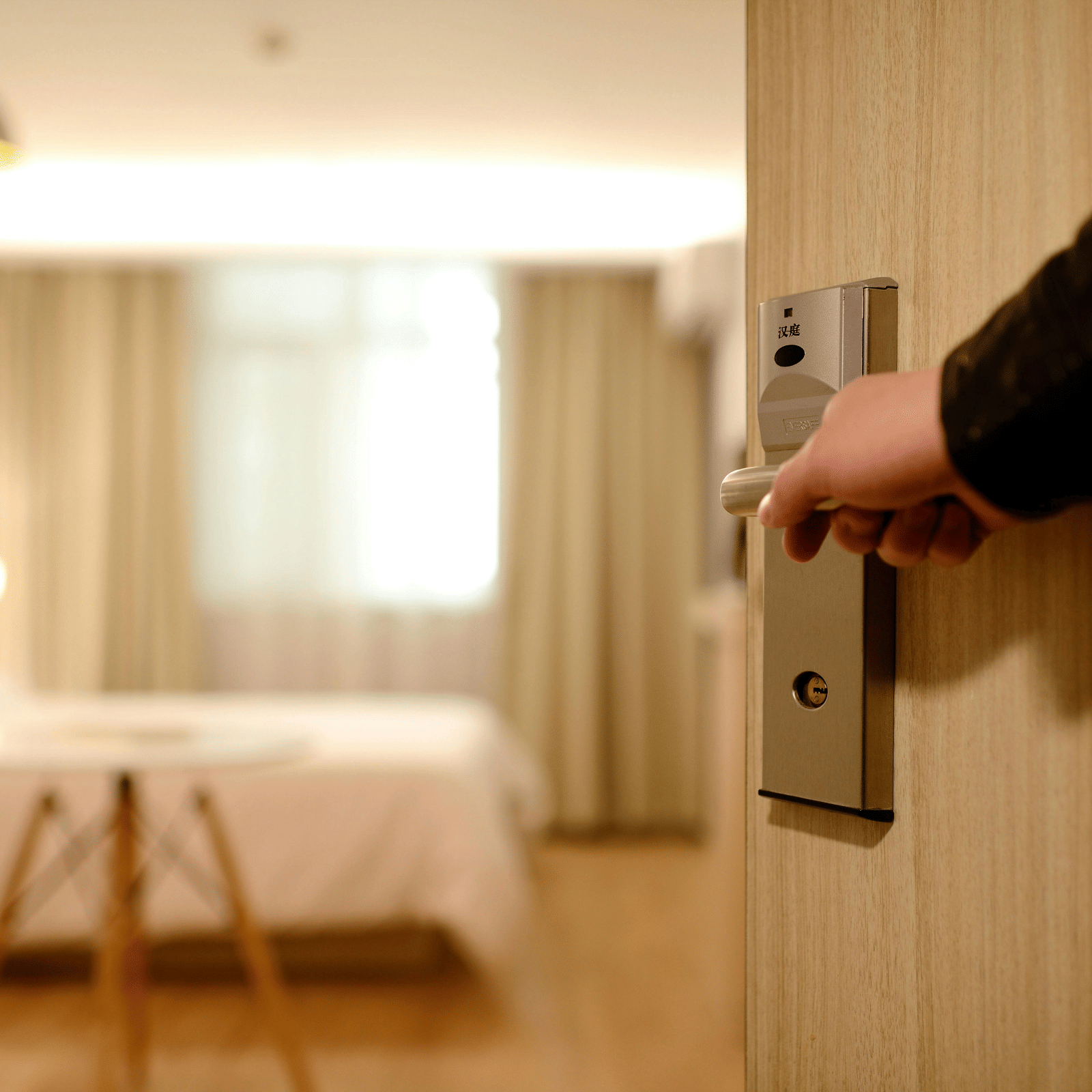 An image showcasing a person's hand opening the door of a room