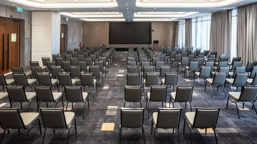 Conference room at Best Western Premier Westlands hotel, arranged classroom-style with neat rows of chairs facing a projector screen for presentations.