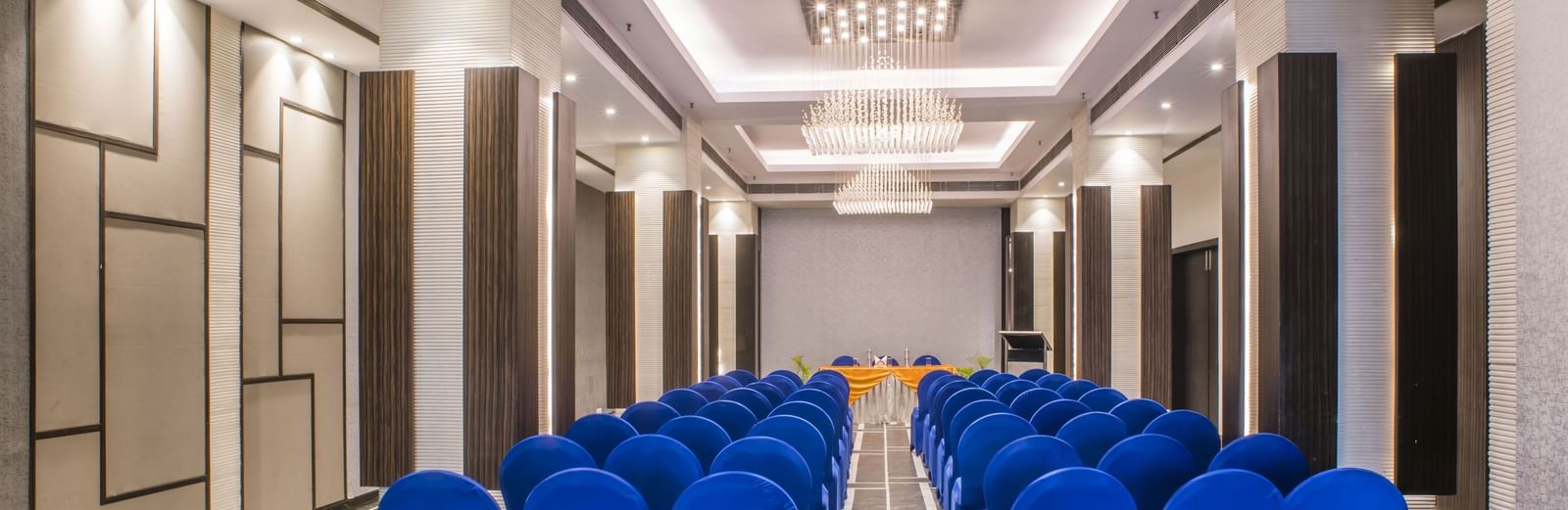 A meeting room setup with blue chairs at The Citi Residence Hotel, Asansol.